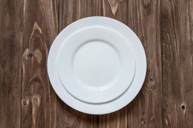 Ahşap arka plan üzerinde iki beyaz seramik tabak