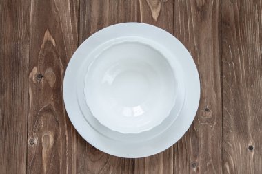 Alt plaka ve ahşap arka plan üzerinde izole çorba tabağı