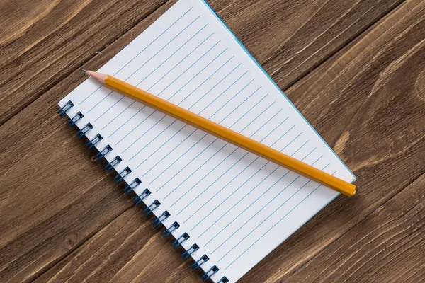 Cuaderno con lápiz sobre fondo de madera — Foto de Stock