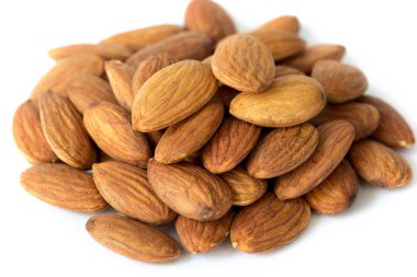 Beyaz arka plan üzerinde kahverengi kayısı çekirdekleri yığını