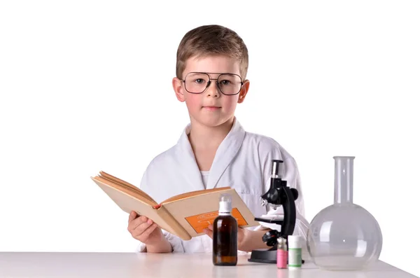 Rapaz cientista com livro aberto na secretária do laboratório — Fotografia de Stock