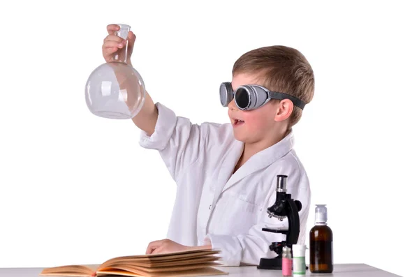 Cieszę się, że chłopiec naukowiec w białą szatę i czarne okulary posiada pustą kolbę — Zdjęcie stockowe