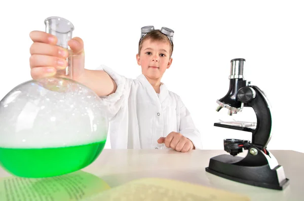 Tudós fiú tart a kezében egy nagy lombik zöld habzó folyadék incide — Stock Fotó