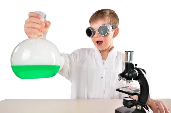 Meglepett tudós fiú fekete szemüveget tart egy lombik a kezében — Stock Fotó