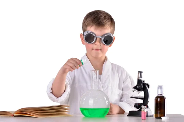 Menino cientista em óculos de proteção colocar reagentes químicos em um frasco — Fotografia de Stock