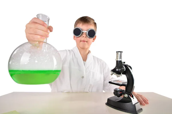 Naukowiec chłopak w okularach czarny posiada jednak duże kolby zielonej piany płynu — Zdjęcie stockowe