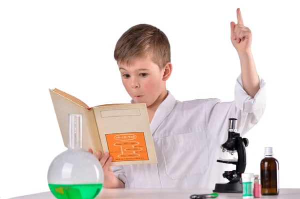 Verbaasd wetenschapper jongen in zijn boek de oplossing vinden — Stockfoto
