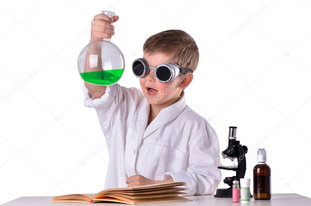 Scientist boy in black glasses holds a flask with green fluid in his hand