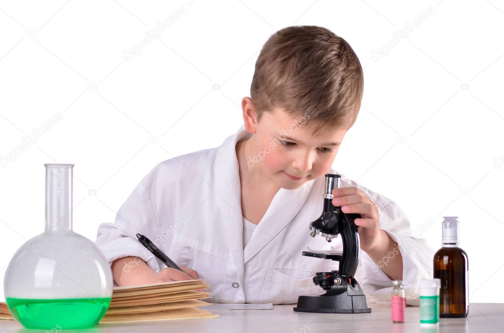 Scientist boy at the desk in the lab write research results