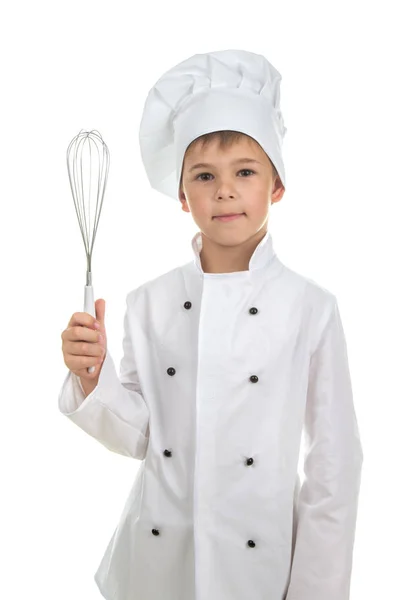 Bonito adolescente em uniforme de chef com um batedor de cozinha, no fundo branco . — Fotografia de Stock