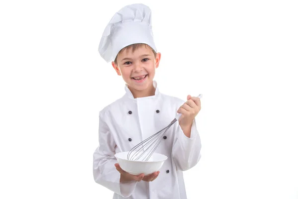Piccolo chef felice mescolando qualcosa con una frusta, su sfondo bianco . — Foto Stock