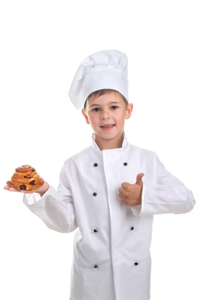 Niño en uniforme de chef con sabroso bollo de pasas de uva gesto bien, aislado en blanco — Foto de Stock