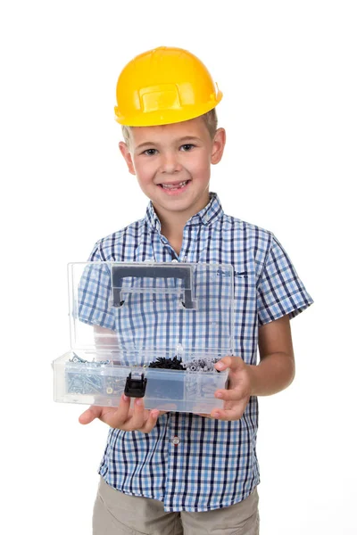 Портрет милого улыбающегося мальчика в голубой клетчатой рубашке и жёлтой каске, с открытым ящиком инструментов на белом фоне — стоковое фото