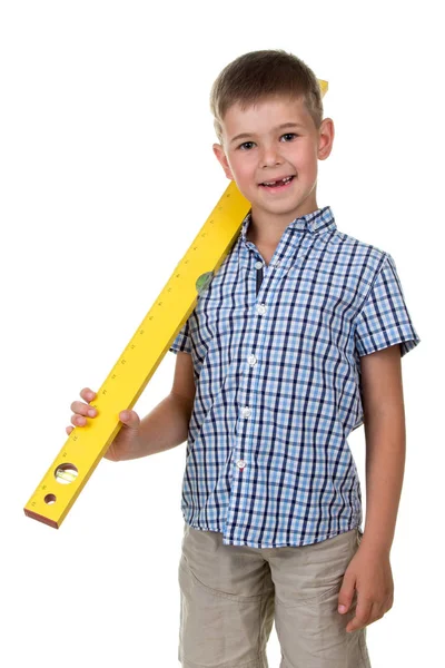 Studio picture of a young funny teenager in a checkered shirt, holding a yellow construction ruler