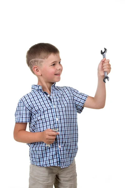 Pequeño constructor guapo de camisa a cuadros azul sosteniendo una llave inglesa y un destornillador, aislado sobre fondo blanco — Foto de Stock