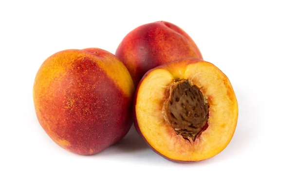 Drie nectarine vruchten met een half gesneden een op witte achtergrond — Stockfoto