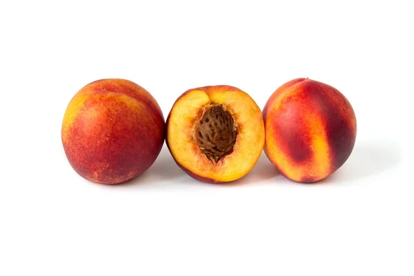 Ряд из трех спелых персиков на белом фоне — стоковое фото