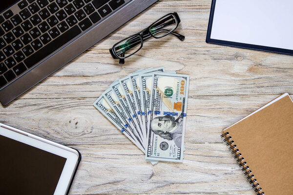 Макропредставление денежного вентилятора на деревянном столе с бизнес-объектами
