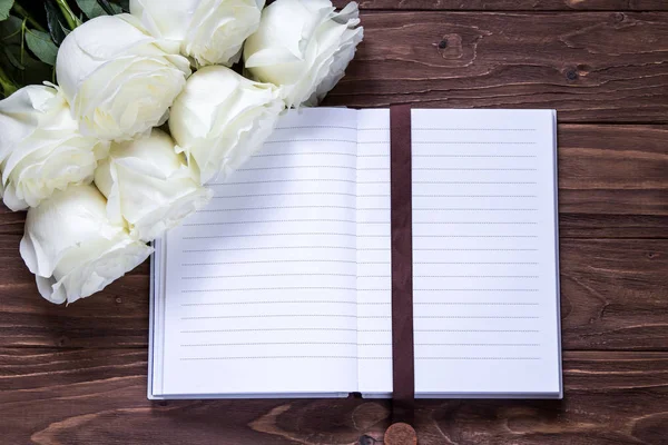 Románticas rosas blancas y un bonito cuaderno vacío para planificar la boda — Foto de Stock