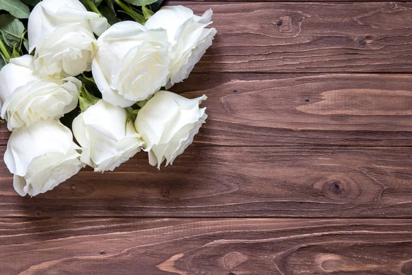 Macro vista de hermoso ramo de rosas blancas en la esquina de la mesa de madera. Fondo de pantalla romántico para parejas queridas — Foto de Stock