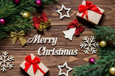 Bell, hediyeler, kar taneleri, yıldızlar ve diğer tinsel ahşap arka plan üzerinde neşeli Noel dekorasyon
