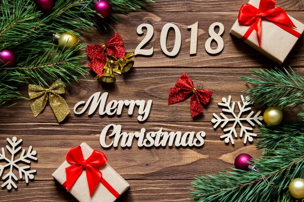 Vrolijk kerstfeest 2019. Kerstcadeaus en bladgoud op de houten