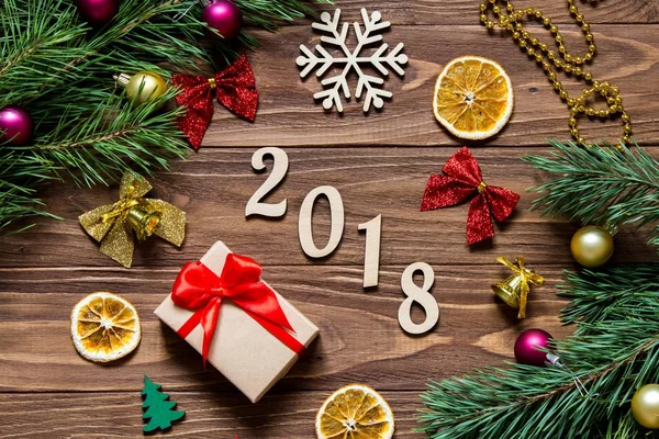 Neujahrstitel 2018 auf dem luxuriösen Holztisch, umgeben von Weihnachtsgeschenk, Zitronenscheiben, Glocken und anderem Weihnachtslametta — Stockfoto