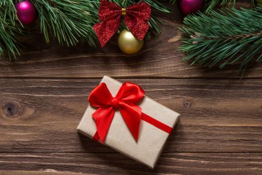 Güzel Noel hediye kutusu makro çam ağacı dalları ekranın üst kısmında ahşap zemin üzerine.