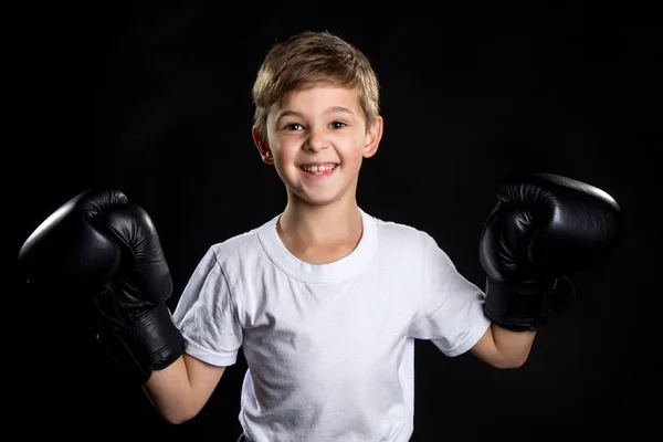 Extremely happy little boxer fighter portrait in black boxing gloves with hands up. The little winner — Stock Photo, Image