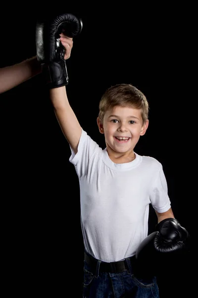 Il piccolo vincitore. Piccolo pugile estremamente felice con la mano destra in guantoni da boxe neri — Foto Stock