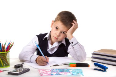 Doğruca kameraya bakarak ileti örneği ile çevrili masada oturan şaşkın üzgün yazma öğrenci