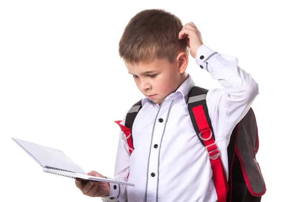 Un alumno resolviendo la tarea, llevando un libro de ejercicios. Retrato de alumno inteligente sobre fondo blanco — Foto de Stock