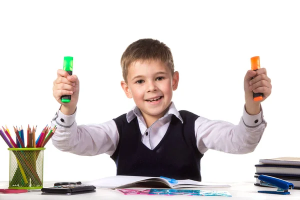 Alumno alegre sentado en el escritorio con rotuladores brillantes rodeados de papelería — Foto de Stock