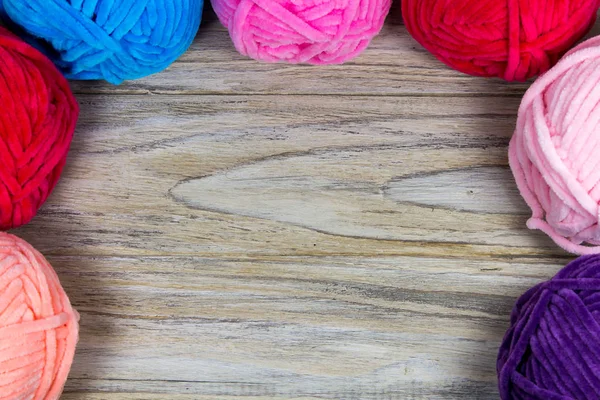 Semicírculo de fios coloridos pastel na mesa de madeira com espaço em branco no centro . — Fotografia de Stock