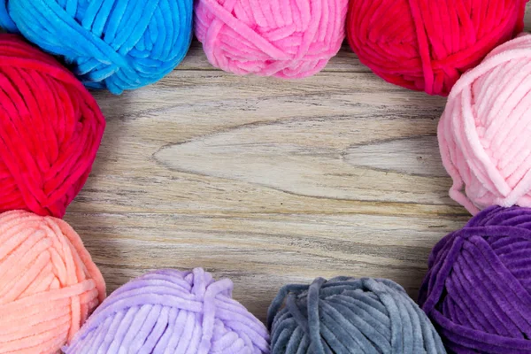 Circled pastel colored yarn on the wooden table blank with blank space in the center. — Stock Photo, Image