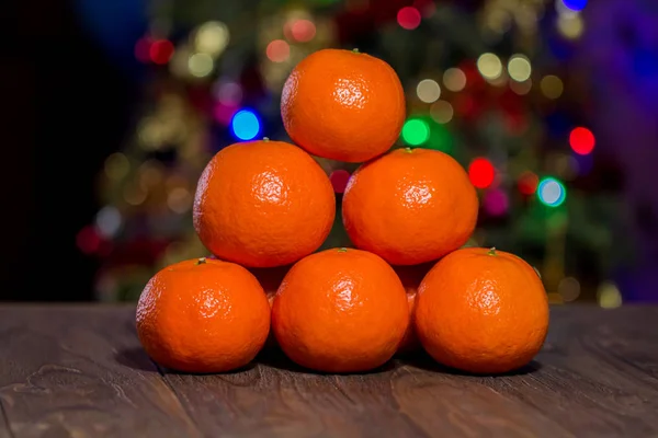 Billiard triangle composition of the tangerines on the center of the wooden table, front macro — Stock Photo, Image