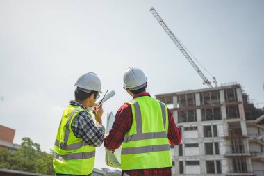 İnşaat mühendisleri radyo iletişimi kullanarak inşaat projesini kontrol ediyorlar. Baş mühendis inşaat kontrolünden bahsetti..