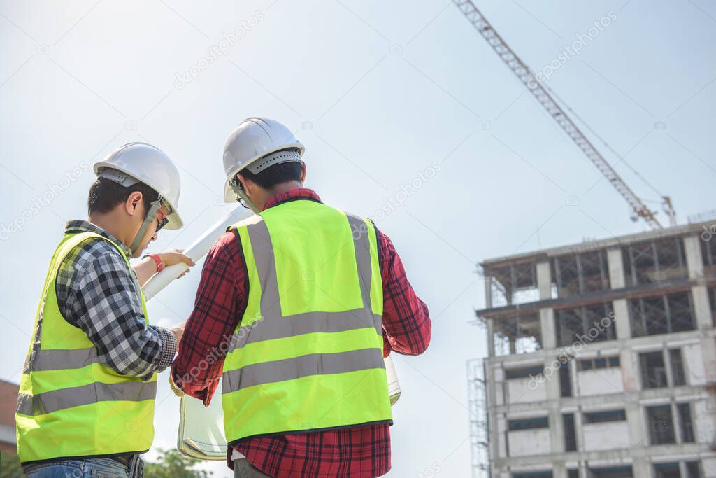 engineers discussion with surveyed about detail of building at construction site.