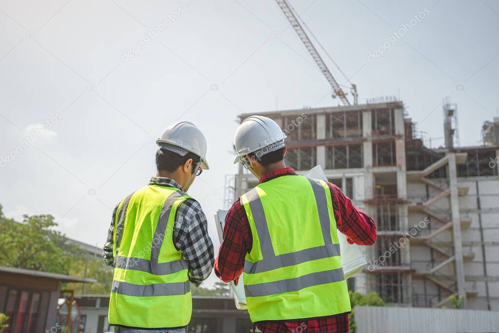 engineers discussion with surveyed about detail of building at construction site.