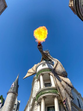 Orlando, FL / USA-11 / 30 / 19: Güneşli bir günde Florida 'nın Orlando kentindeki Universal Stüdyolarında Gringotts Bank' ın yukarısında ateş püskürten ejderha.