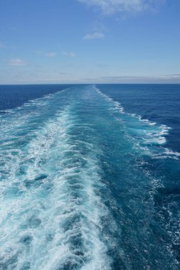 Bir yolcu gemisi güzel güneşli bir günde beyaz bulutlar ve Atlantik Okyanusu 'ndaki mavi denizlerle uyanıyor..