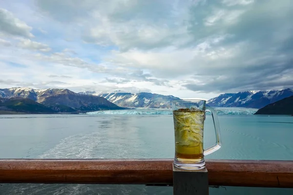 船がハバード氷河から航海している間にクルーズ船の手すりの上にビールや飲み物のガラス — ストック写真