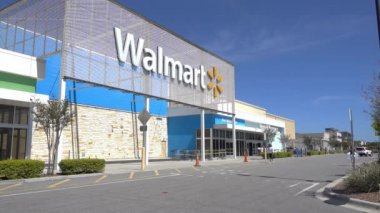 Orlando, FL / USA - 5 / 8 / 20: Bir Walmart perakende mağazasının dış cephesinde insanlar dükkana giriyor ve oradan geçen arabalar.