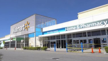 Orlando, FL / USA - 5 / 8 / 20: Bir Walmart perakende mağazasının dış cephesinde insanlar dükkana giriyor ve oradan geçen arabalar.