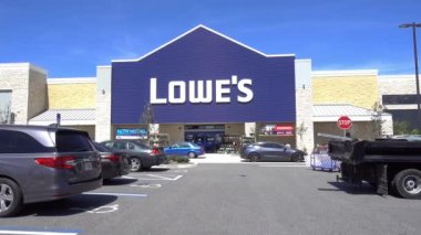 Orlando, FL / USA - 5 / 8 / 20: Lowes Home Improvement hırdavat mağazasının dış vitrininde arabalar geçiyor ve insanlar alışverişe gidiyor.