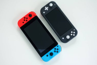 Orlando, FL / USA -5 / 27 / 20: Çok oyunculu bir Nintendo Switch ve tek oyuncu Nintendo Switch Lite oyun konsolları yan yana.