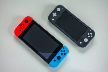 Orlando, FL / USA -5 / 27 / 20: Çok oyunculu bir Nintendo Switch ve tek oyuncu Nintendo Switch Lite oyun konsolları yan yana.