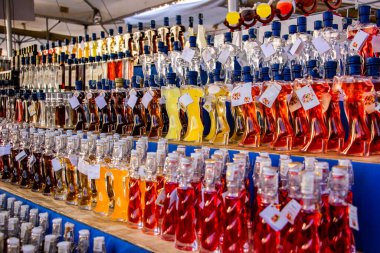 Seçici odaklanma. İtalya 'da geleneksel sokak pazarında satılmak üzere çeşitli şekillerde satılan küçük içki şişeleri. Tipik İtalyan hatırası. Limoncello, grappa, çilek, erik, vanilya, çiçek ve fındık.