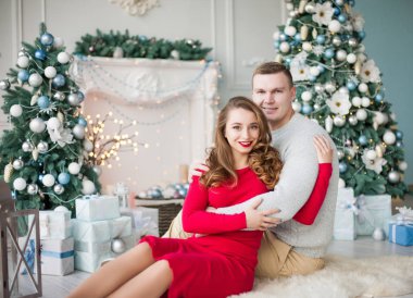 Mutlu genç insanlar birbirlerine Noel ağacı yakınındaki şömine tarafından hediyeler vermek. Yeni yıl kavramı.