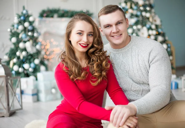 Mutlu genç insanlar birbirlerine Noel ağacı yakınındaki şömine tarafından hediyeler vermek. Yeni yıl kavramı.